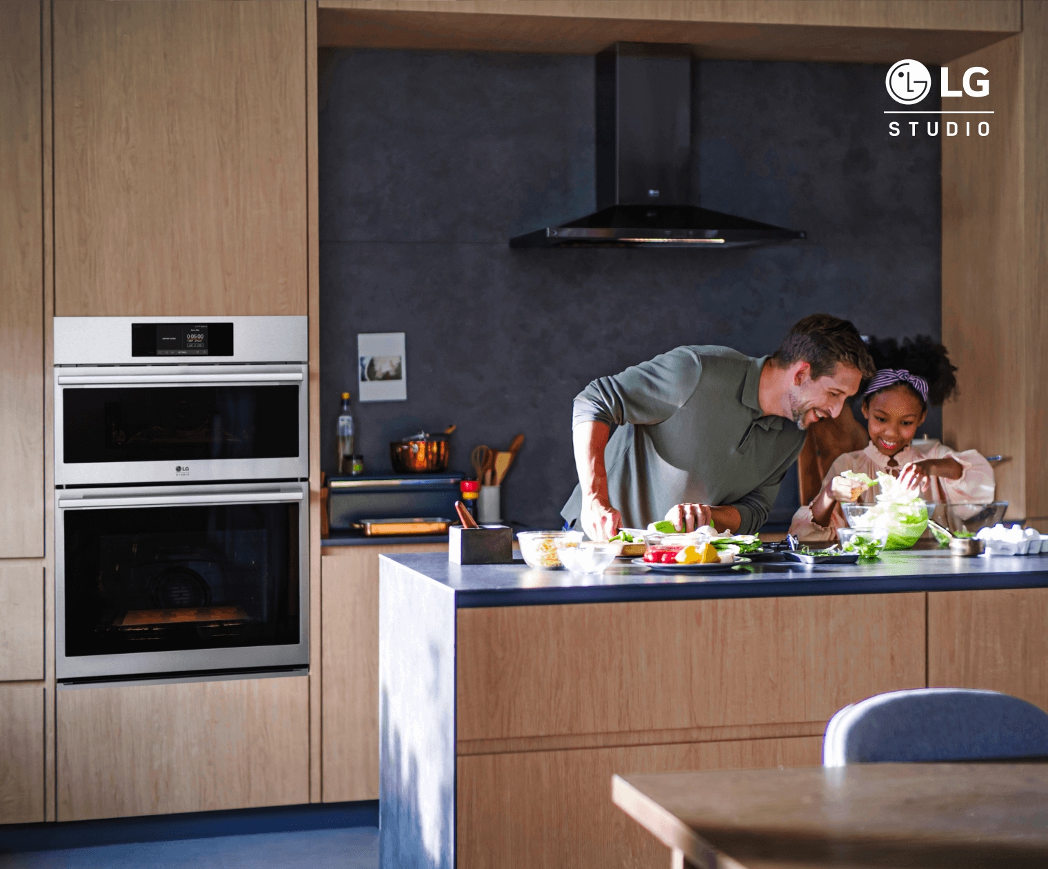 Father and daughter making salad in the kitchen.